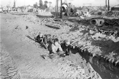 810821 Afbeelding van enkele kinderen, spelend in het zand, op het bouwterrein bij de bouw van de Marnixbrug over de ...